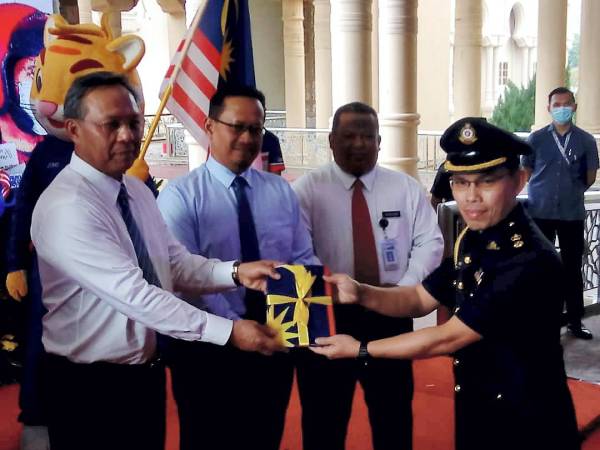 Hasni (kiri) menyerahkan Jalur Gemilang sempena Majlis Pelancaran Bulan Kebangsaan dan Kempen Kibar Jalur Gemilang Peringat Negeri Johor 2020 di Kota Iskandar, hari ini.