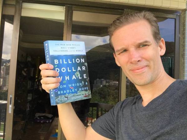 Tom Wright menunjukkan buku Billion Dollar Whale yang ditulis bersama dengan rakan sekerjanya, Bradley Hope.