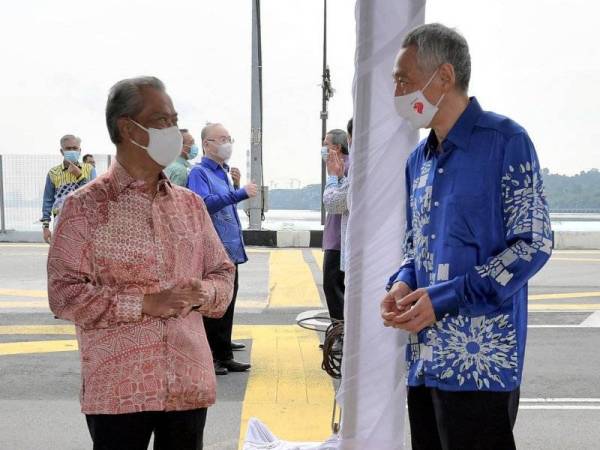 Perdana Menteri Tan Sri Muyhiddin Yassin beramah mesra bersama rakan sejawatannya dari Singapura Lee Hsien Loong selepas menyaksikan "persetujuan" untuk meneruskan projek Sistem Transit Rapid (RTS) yang menghubungi Johor Bahru-Singapura hari ini. - Foto Bernama
