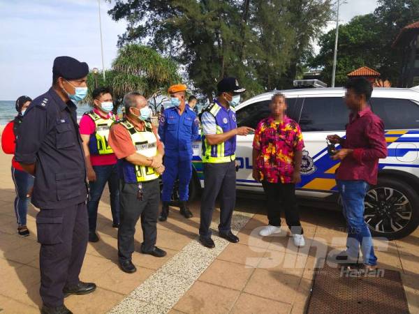 Mohamad Noor melakukan pemeriksaan ke atas pengunjung pusat peranginan Teluk Cempedak. 