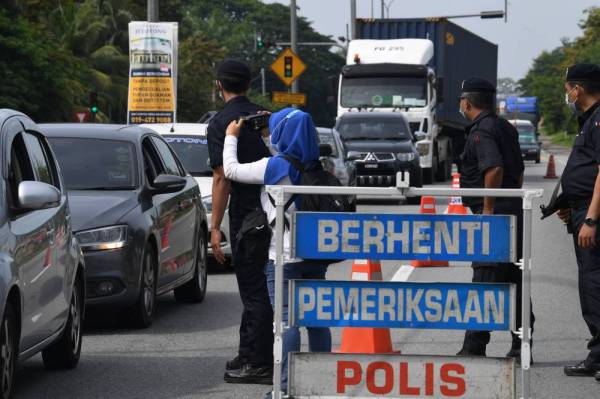 Anggota Polis dari IPD Kubang Pasu melakukan Sekatan Jalan Raya (SJR) berikutan pelaksanaan TEMCO di Kubang. -Foto Bernama