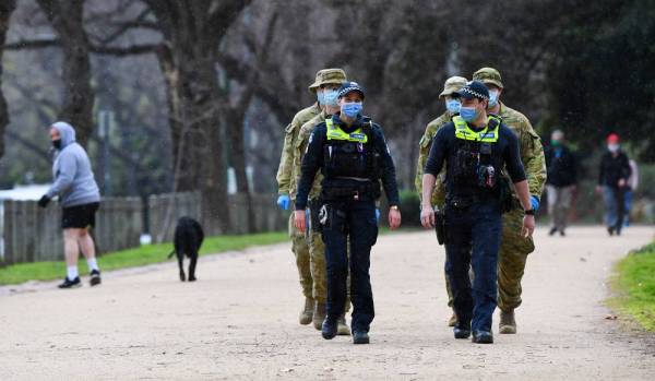 Anggota polis dan tentera melakukan rondaan di trek larian popular di Melbourne hari ini. - Foto: AFP