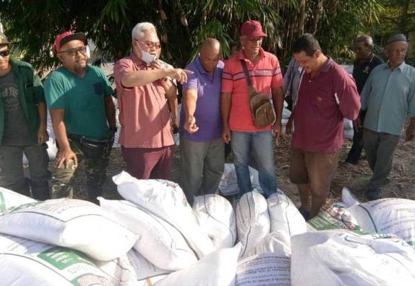 Noh (tiga dari kiri) mengagihkan sumbangan baja organik kepada petani di Parlimen Tanjong Karang.