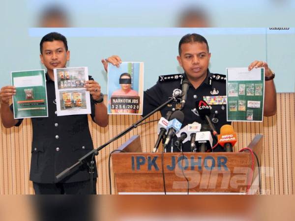 Ayob Khan (kanan) menunjukkan gambar suspek dan rampasan pelbagai jenis dadah dalam beberapa siri serbuan selepas mengadakan sidang akhbar di IPK Johor, Johor Bahru hari ini.