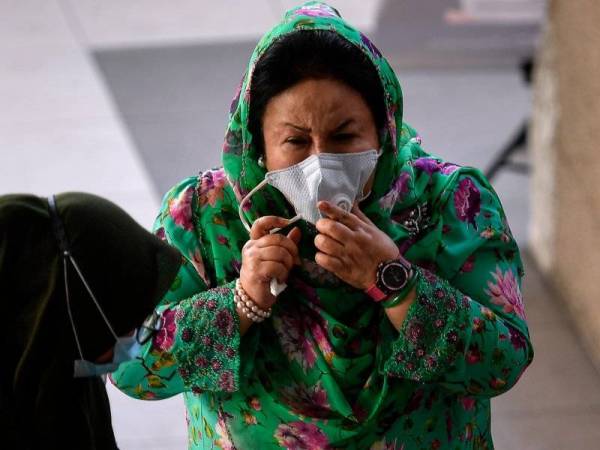 Rosmah sedang memperbetulkan pelitup mukanya di Kompleks Mahkamah Kuala Lumpur. - Foto Bernama