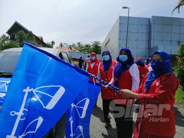 Noraini (depan) menyempurnakan gimik pelepasan 24 kenderaan Wanita UMNO Bahagian sempena program Ziarah Kasih Skuad Sayang 3K di Felda Residence, Sungkai hari ini. 