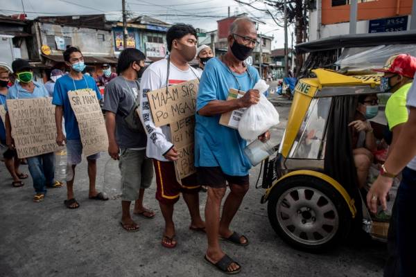 Pemandu bas 'jeepney' yang terjejas akibat Covid-19 beratur ketika menerima bantuan makanan di Manila semalam. - Foto AFP