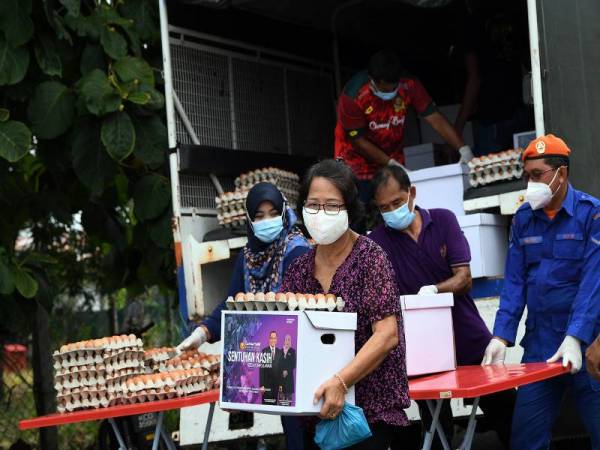 Penduduk Napoh ceria menerima bantuan makanan daripada Pengerusi Jawatankuasa Kebajikan Negeri Kedah yang juga ADUN Bukit Kayu Hitam Halimaton Shaadiah Saad (kiri) pada penyerahan bantuan Covid-19 TEMCO Daerah Kubang Pasu kepada penduduk setempat di Dewan Kampung Napoh hari ini. - Foto Bernama