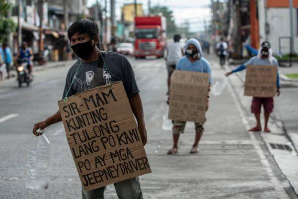 Pemandu bas 'jeepney' beratur di sebatang jalan di Manila bagi meminta bantuan makanan daripada orang awam selepas hilang pendapatan akibat pandemik Covid-19.