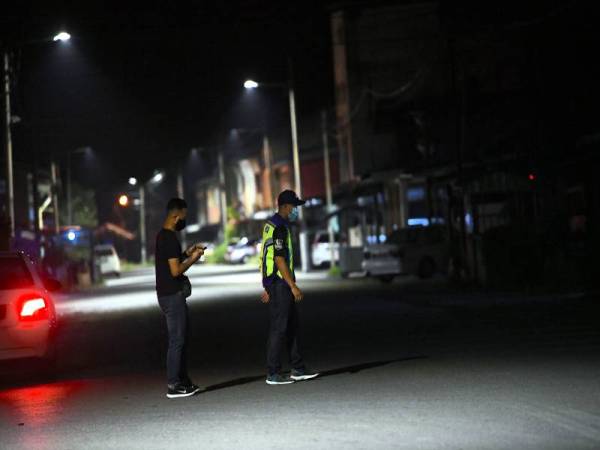 Anggota polis dari IPD Kangar melakukan sekatan jalan raya berikutan pelaksanaan Perintah Kawalan Pergerakan Diperketatkan (PKPD) secara pentadbiran di daerah Sanglang bermula malam tadi. - Foto Bernama