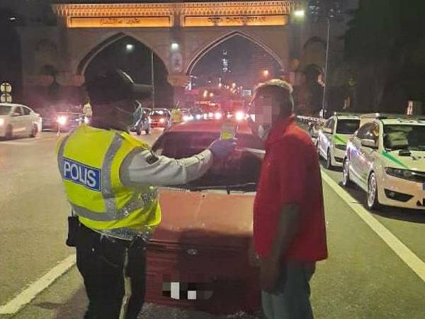 Salah seorang pemandu sedang menjalani ujian kandungan alkohol ketika Ops Alkohol dan Pencegahan Jenayah di Petaling Jaya, semalam.