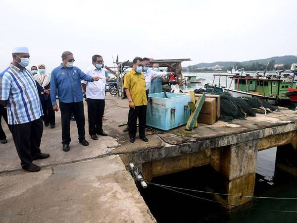 Che Abdullah (tiga dari kanan) meninjau masalah mendapan pasir di Pelabuhan Lembaga Kemajuan Ikan Malaysia Chendering yang menyebabkan jumlah pendaratan ikan di situ semakin merosot.