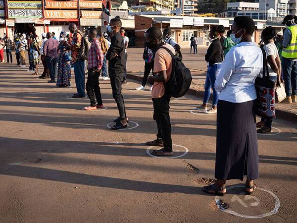 Orang ramai berdiri dalam bulatan untuk menjaga penjarakan fizikal bagi membendung penularan Covid-19 di Kigali. - Foto AFP