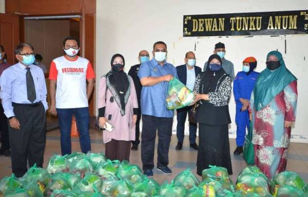 Muhammad Sanusi (empat, kiri) menerima sumbangan daripada NGO untuk diagihkan ke kawasan terjejas. - Foto Urusetia Penerangan Darul Aman (UPDA)