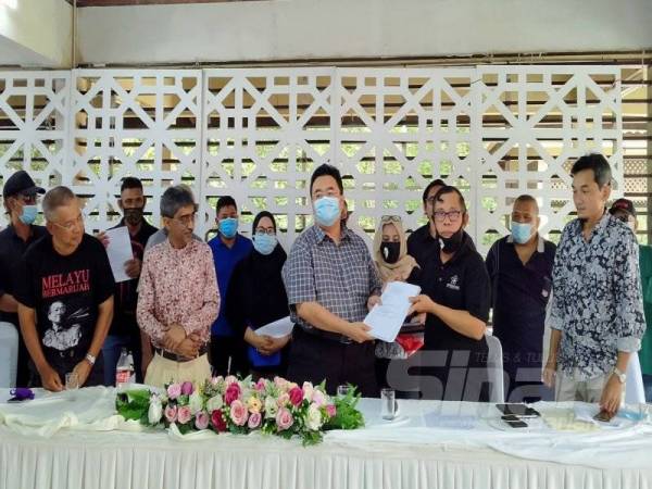 Anuar (tiga dari kanan) menunjukkan surat akuan keluar parti yang diserahkan Ahli Bersatu Bahagian Merbok pada sidang akhbar di Sungai Petani hari ini.