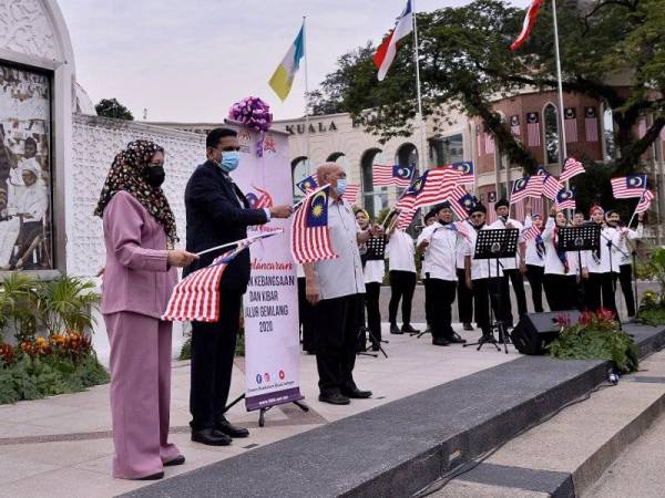 Santhara (dua dari kiri) bersama Nor Hisham (tiga dari kiri) mengibarkan Jalur Gemilang pada Majlis Pelancaran Kempen Kibar Jalur Gemilang Peringkat Wilayah Persekutuan Kuala Lumpur di Dataran Merdeka hari ini. - Foto Bernama