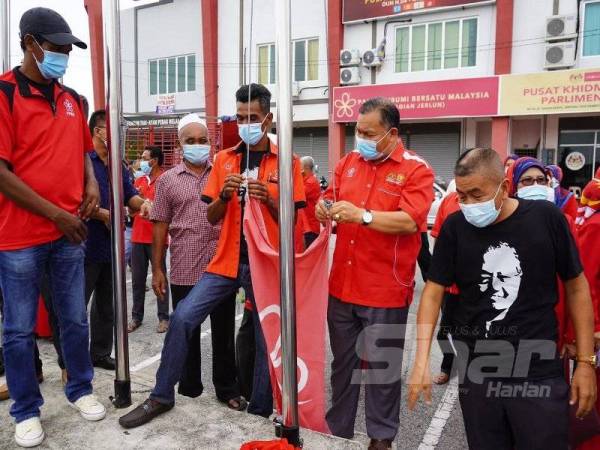 Aziz (dua, kanan) bersama ahli akar umbi secara simbolik menurunkan bendera dan menanggalkan papan tanda parti Bersatu.
