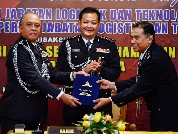 Abdul Hamid (tengah) menyaksikan penyerahan dokumen Pengarah Jabatan Logistik dan Teknologi Bukit Aman daripada Datuk Seri Rosli Ab Rahman (kiri) kepada Datuk Shukri Abdullah pada Majlis Serah Terima Tugas Pengarah Jabatan Logistik dan Teknologi di Mess Kanan, Bukit Aman hari ini. Foto - Bernama