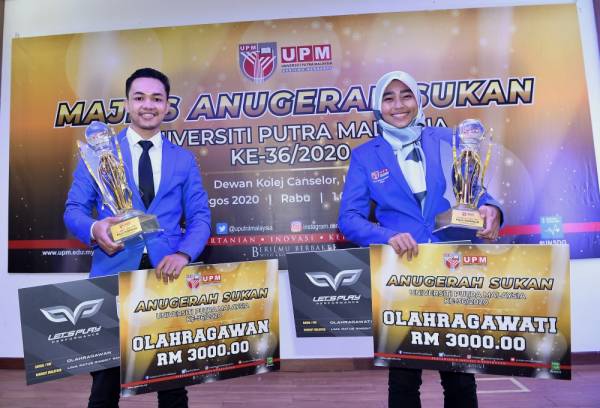 Mohamad Lutfi dan Hanis Nadiah bersama replika cek bernilai RM3,000 berserta piala masing-masing ketika menghadiri Majlis Anugerah Sukan UPM Ke-36 di Universiti Putra Malaysia (UPM) hari ini. - Foto Bernama
