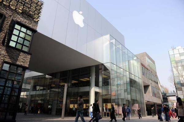 Gambar fail menunjukkan beberapa orang berjalan di luar sebuah kedai menjual produk Apple di Beijing, China. - Foto AFP