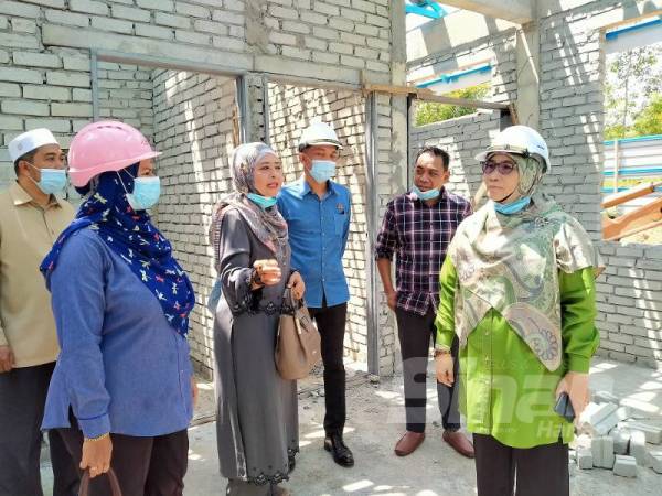 Siti Ashah (kanan) melakukan lawatan ke tapak pembinaan Tabika Kemas Bandar Sri Astana hari ini.