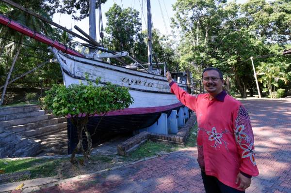 Che Muhamad Azmi menunjukkan tinggalan sejarah iaitu perahu besar yang diberi nama SABAR T82 daripada jenis pinis dogol di Muzium Negeri Terengganu baru-baru ini.