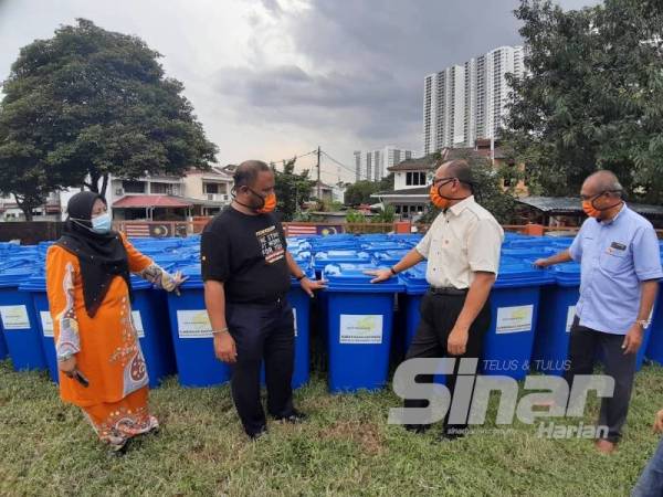 Izham (dua dari kanan) melihat tong sampah yang disumbangkan oleh KDEBWM untuk diagihkan kepada pengguna di DUN Pandan Indah.