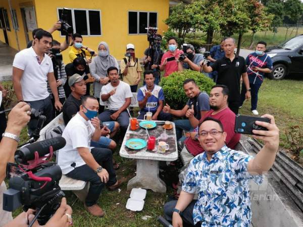 Amir Khusyairi berswafoto bersama penduduk pada program walkabout Felda Trolak Utara hari ini. 