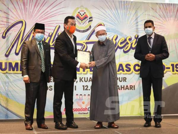 KK Chai (dua dari kiri) ketika menerima sijil penghargaan daripada Dr Zulkifli atas usaha dan sumbangan dalam melaksanakan tanggungjawab sosial korporat (CSR) kepada masyarakat.