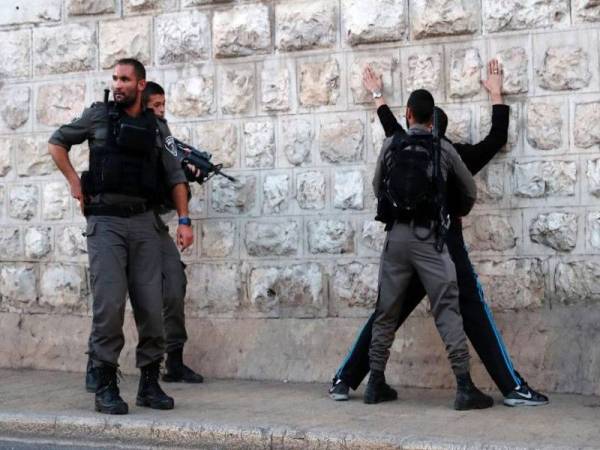 Gambar fail menunjukkan beberapa pengawal sempadan Israel memeriksa seorang lelaki Palestin di luar pintu Damsyik, Kota Lama Baitulmuqaddis. - Foto AFP