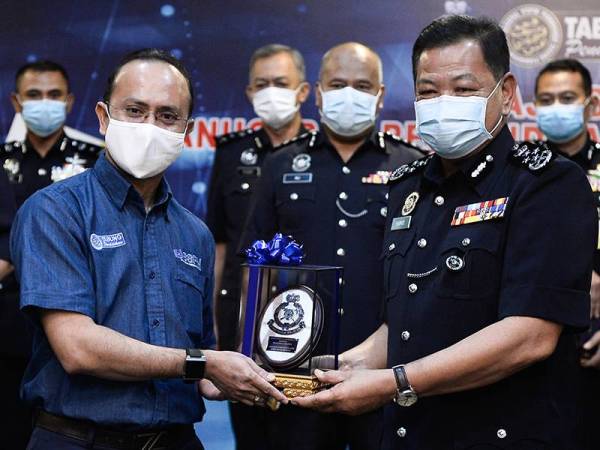 Abdul Hamid (dua dari kanan) menyampaikan cenderahati sebagai tanda penghargaan kepada Ketua Eksekutif PTPTN, Ahmad Dasuki Abdul Majid (dua dari kiri) pada Majlis Anugerah Perkhidmatan Cemerlang Polis Diraja Malaysia Tahun 2019 di Ibu Pejabat Polis Bukit Aman hari ini. - Foto Bernama