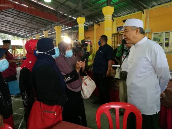 Ahmad Zahid beramah mesra dengan jemaah yang ditemui di Masjid Saidina Uthman Ibnu Affan, Felda Besout 3, Sungkai, di sini hari ini.