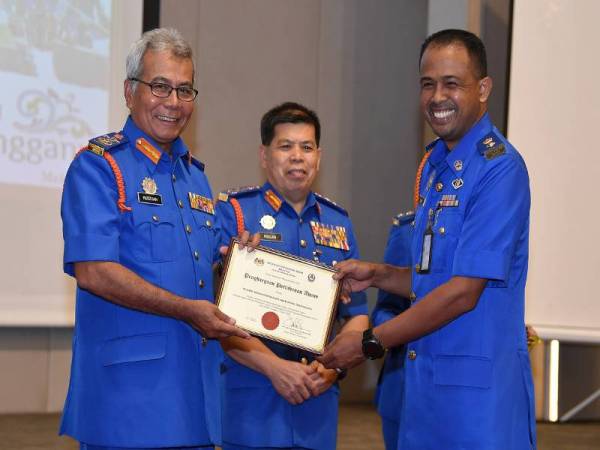 Mohd Redzuan Yusof (kiri) menyampaikan sijil penghargaan penugasan COVID-19 kepada Pengarah APM Terengganu Leftenan Kolonel (PA) Che Adam A Rahman (kanan) pada Majlis Perjumpaan Khas Bersama Warga Angkatan Pertahanan Awam Malaysia (APM) di sebuah hotel malam tadi. - Foto Bernama