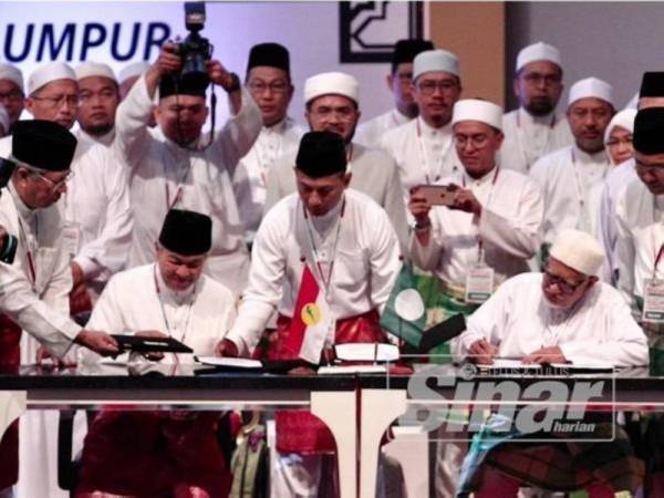 
Ahmad Zahid (kiri) bertukar dokumen dengan Abdul Hadi selepas menandatangani Piagam Muafakat Nasional di antara Pas dan UMNO di Kuala Lumpur pada 14 September 2019.