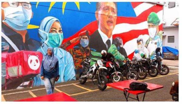 Pengunjung tidak melepaskan peluang bergambar berlatar belakang mural frontliner. Foto Instagram Makan Herritage.