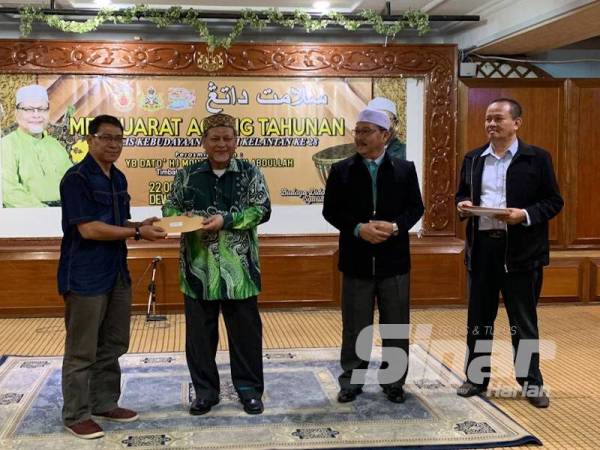 Mohd Amar (dua dari kiri) menyampaikan sumbangan kepada wakil penggiat seni yang hadir pada Mesyuarat Agung Tahunan kali-28 Majlis Kebudayaan Negeri Kelantan di Kompleks Kota Darulnaim hari ini.