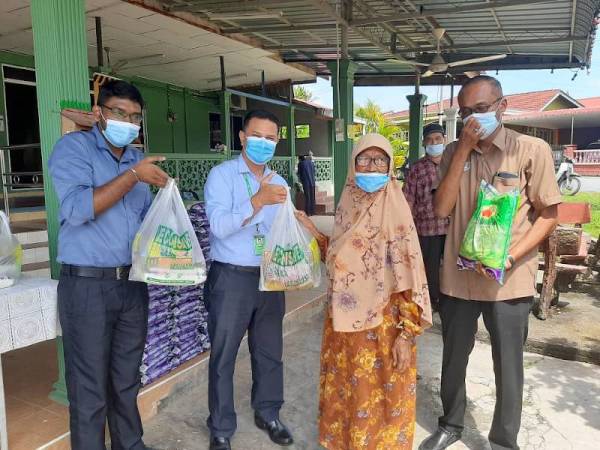 Dari kiri; Devanathan dan Zamzuri semasa menyampaikan sumbangan Econsave Cash & Carry kepada seorang penduduk di Surau Taman Pertama, Pokok Sena pada Rabu lalu. - Foto ihsan Econsave Pokok Sena