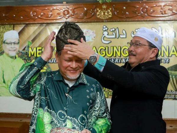 Exco Perpaduan Masyarakat, Kebudayaan, Warisan dan Pelancongan, Mejar (B), Datuk Md Anizam Abdul Rahman (kanan) memakaikan tanjak kepada Mohd Amar pada Majlis Kebudayaan Negeri Kelantan di Kompleks Kota Darulnaim hari ini.