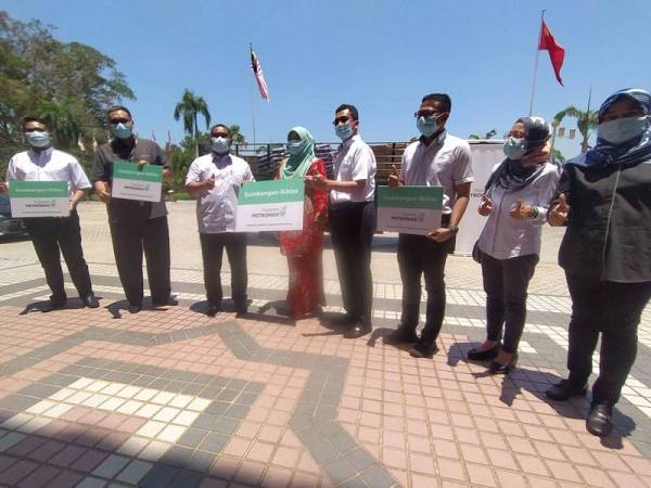 Muhammad Sanusi (tiga dari kiri) bersama wakil Yayasan Petronas selepas majlis penyerahan sumbangan kepada 300 keluarga B40 terjejas di Wisma Darul Aman di sini hari ini.