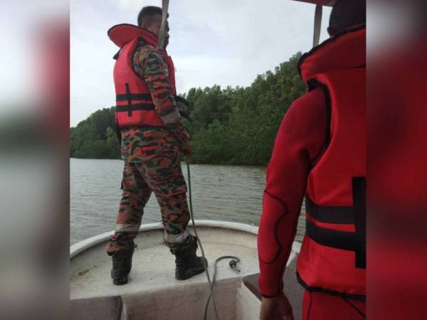 Anggota bomba menjalankan operasi mencari dan menyelamat lelaki yang dikhuariti hilang di Sungai Deraka hari ini. - Foto JBPM Perak.