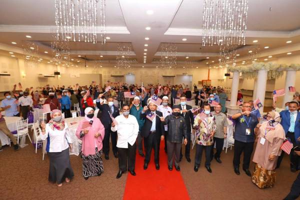 Tuan Ibrahim (lima dari kiri) bersama tetamu mengibarkan Jalur Gemilang bagi menyemarakkan sambutan kemerdekaan di Grandara Hall, Pendek, Kota Bharu hari ini.