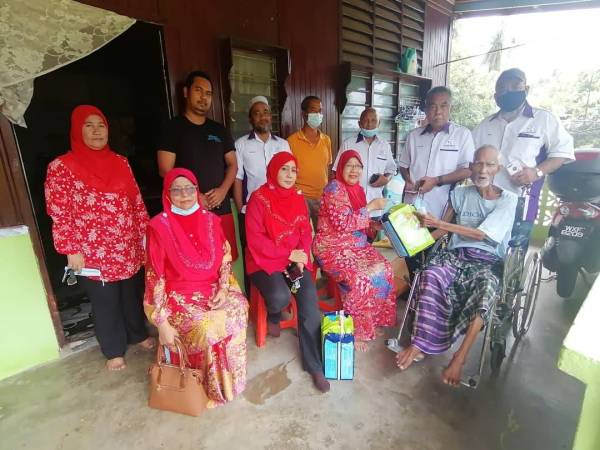 Latipah menyampaikan sumbangan kepada Yusfa Ashya (kiri) di jalan Hujan Panas, Masjid Tanah, baru-baru ini.
