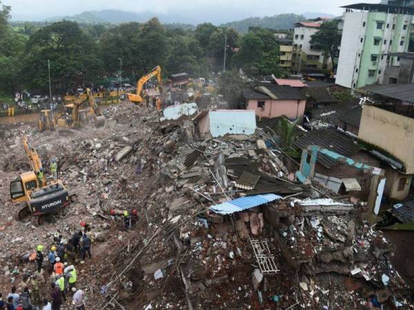 Anggota penyelamat melakukan operasi hari ini bagi mencari mangsa terselamat selepas sebuah apartmen lima tingkat runtuh di Mahad semalam. - Foto AFP