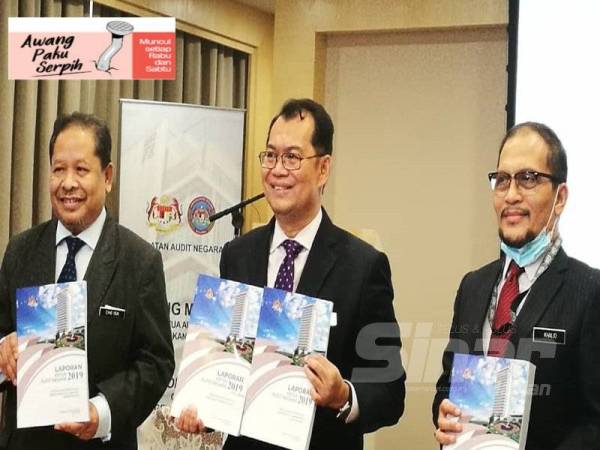 Nik Azman (tengah) menunjukkan buku Laporan Audit Negara Tahun 2019 pada sidang akhbar di Putrajaya hari ini.