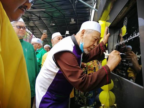 Hashim menurunkan tandatangan sebagai simbolik perasmian Kompleks Tarbiah Riyadhus Solehen Pondok Muallim hari ini. 