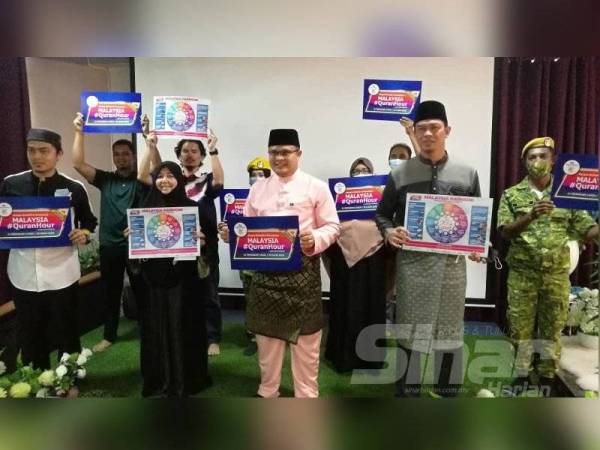 Mohd Akmal (tengah) bersama wakil Rumah Ngaji Perak dan petugas Pusat Media KKMM menunjukkan plakad Malaysia #QuranHour sebagai tanda sokongan.