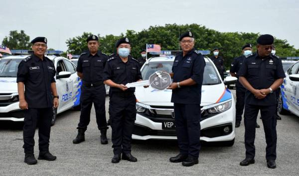 Zainal Abidin (dua, kanan) menyerahkan replika kunci MPV Honda Civic 1.8 kepada Eng Lai di IPK Melaka. - Foto Bernama