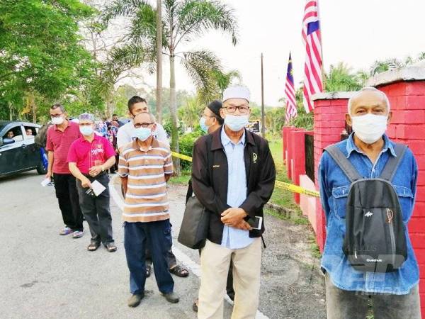 Seorang warga emas, Othman Saad, 71, (hadapan) antara yang terawal hadir untuk menunaikan tanggungjawab sebagai pemilih di Pusat Mengundi Sekolah Kebangsaan (SK) Besout 5, hari ini.