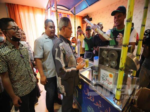 Mustapa melawat dan melihat cara penghasilan air tebu kiosk yang diusahakan Mohd Rizuan Shah sempena program di Royal Guest House hari ini. 