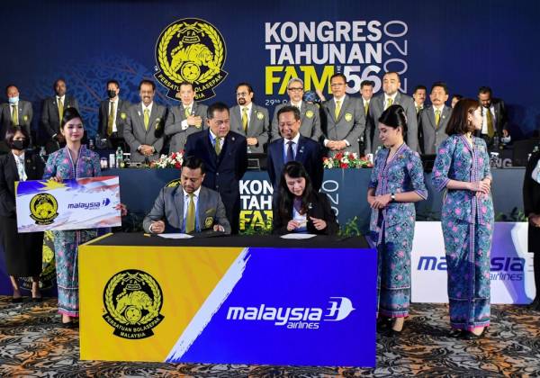 Presiden Persatuan Bola Sepak Malaysia (FAM) Datuk Hamidin Mohd Amin (berdiri tiga, kiri) menyaksikan majlis menandatangani perjanjian lanjutan usahasama bagi tempoh 2021 hingga 2023 antara FAM dan Malaysia Airlines Berhad sempena Kongres Tahunan FAM ke-56 hari ini. -Foto Bernama